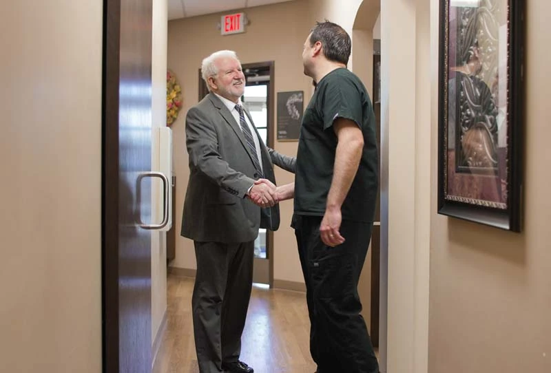 Dr. Coursey shaking hands with a patient at Tulsa Premier Dentistry